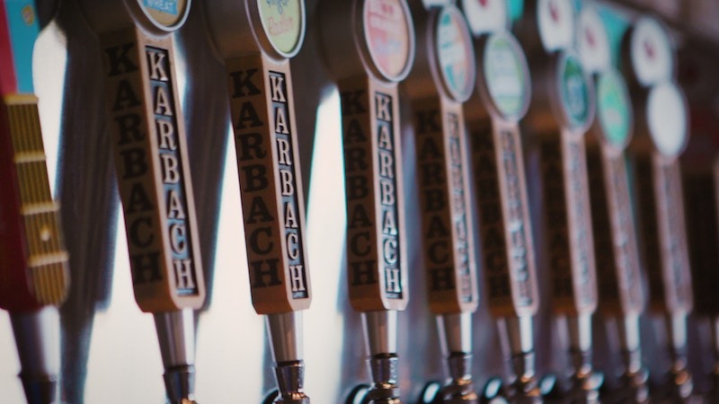 Karbach Brewing Co. beer handles in line along a bar wall